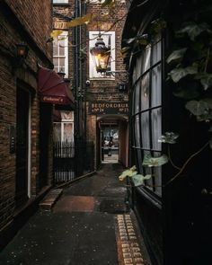 an alley way with brick buildings and windows