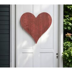 a wooden heart hanging on the side of a door