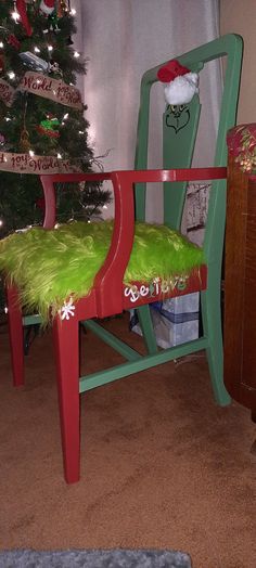 a green chair sitting in front of a christmas tree