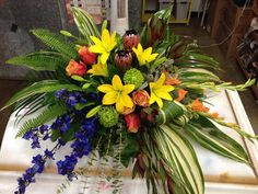 a bouquet of flowers sitting on top of a white counter next to blue and yellow flowers