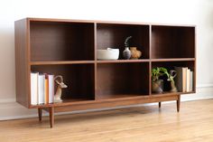 a wooden shelf with books and vases on it