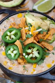 a bowl filled with beans, tortilla chips and avocado on top