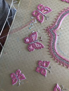 some pink and silver sequins are laying on a piece of fabric with other sequins