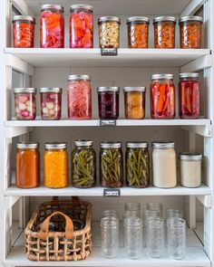 many jars filled with different types of food on shelves in a kitchen or pantry area