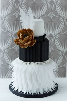 a wedding cake with feathers on it and a flower in the middle is featured for an article