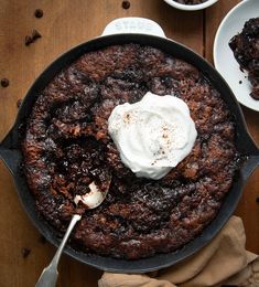 a skillet filled with chocolate cake and whipped cream