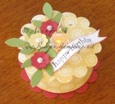 a close up of a birthday card with flowers on it and a candle in the middle