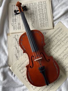 an old violin laying on top of sheet music