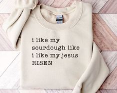 Just the shirt for any person who loves sourdough and Jesus! ▸ Gildan 18000 Sweatshirt ▸ 55% cotton/45% polyester ▸ Unisex Adult Sizing  ▸ Props used In photos are NOT included with purchase  WASHING INSTRUCTIONS ▸ Wash inside out, in cold water, on gentle cycle. Tumble dry low or let air dry  ▸ Do not use Fabric Softeners or Bleach ▸ Do not dry clean. Avoid ironing on the design.  SIZE ▸ Take a look at the photos to see a specific sizing chart for this sweatshirt style ▸ Please note that these shirts are unisex size meaning they are not women's fitted shirts.  ▸ Lay your favorite shirt at home flat and measure armpit to armpit to compare to the size chart in the photos RETURNS OR EXCHANGES ▸ All of our shirts are custom printed just for you so we do not accept returns or exchanges due to Bible Mom Shirt, Funny Christian Shirts Humor, Sourdough Bread Shirts, Made To Worship Sweatshirt, Sourdough Shirt, Faith Based Sweatshirts, Crunchy Mama, Baker Shirts