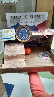 a person is holding up a miniature island made out of cardboard and other items from rhode