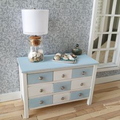 a blue and white dresser with seashells on top