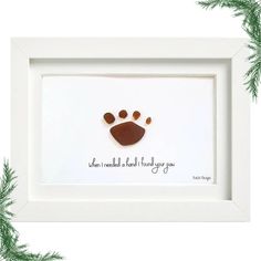 a white frame with a dog's paw in it