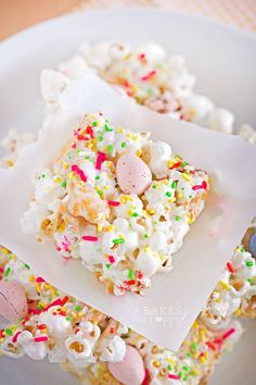 a white plate topped with cake and marshmallows covered in sprinkles