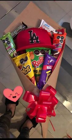 a box filled with candy and candies on top of a floor next to a person's feet