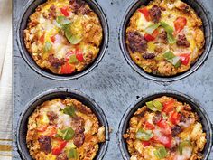 four muffins in a pan with toppings on top, ready to be eaten