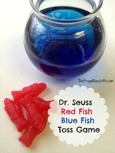 a red fish and blue fish toy are next to a glass bowl with water in it