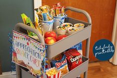 a cart filled with lots of food and snacks on top of a hard wood floor