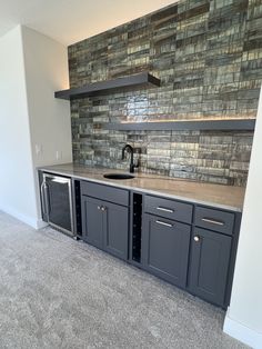 an empty kitchen with gray cabinets and tile backsplash