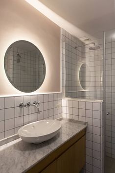 a bathroom with a sink, mirror and shower stall in it's own area