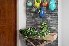 several hanging planters on the side of a brick wall