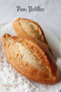 two loaves of bread sitting on top of a white lace doily with the words pan bollos