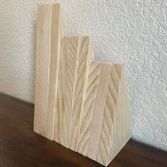 a piece of wood sitting on top of a wooden table next to a white wall