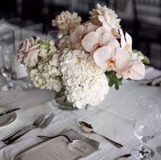 the table is set with flowers and silverware