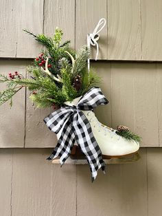 a pair of shoes hanging on the side of a building with evergreen and pine cones