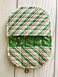 a green and red striped bag with candy canes on it's front pocket