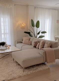 a living room filled with furniture and white curtains