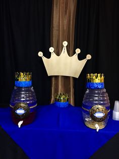 two vases with crowns are on a blue table cloth