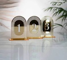 three gold and black numbered numbers on a white table