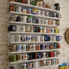 there are many coffee cups on the shelves