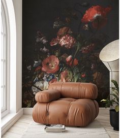 a leather chair sitting in front of a wall with flowers on it