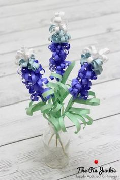 a vase filled with blue and white flowers on top of a wooden table