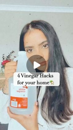 a woman holding a bottle of vinegar hacks for your home screen shot with the caption 4 vinegar hacks for your home