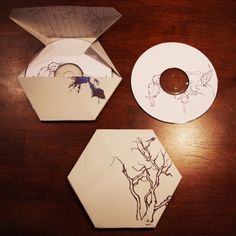 an open cd case sitting on top of a wooden table next to a paper plate