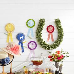 a table topped with plates and cups filled with food next to wreaths on the wall