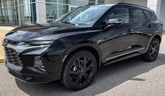 a black chevrolet suv parked in front of a building