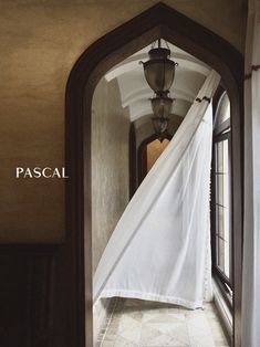 an open doorway with a white curtain hanging from it's side and the words pascal above it