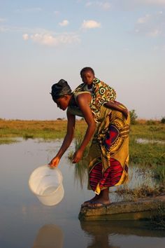 a woman is standing in the water with a white object