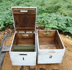 two wooden boxes with numbers on them sitting in the sand