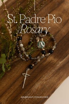 a rosary and cross on a wooden board with the words st padre pic rosary