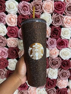 a hand holding a starbucks coffee cup in front of pink and white roses with gold foil