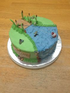 a cake that is sitting on top of a metal plate with grass and water in it