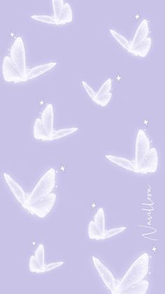 several white butterflies flying in the sky with stars on their wings, all facing different directions