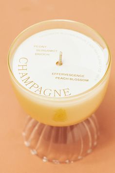 a candle that is sitting on top of a glass stand with the words champagne in it