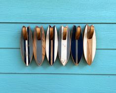 five surfboards mounted to the side of a blue wall