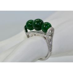 This is part of Chairish’s Fine Jewelry assortment.  Jadeite Bead and Diamond Ring  This gorgeous ring comes out of a Sotheby's Fine Jadeite and Jade auction in Hong Kong. It consists of three (3) Jadeite Beads 7.75 round on a Diamond surround and base. This ring is Jadeite, not Jade or Nephrite bit real Jadeite. These Beads glow are an intense green and translucent and it comes with a certificate from Hong Kong Jade stone Laboratory stating no resin is detected, a fine Fei Cui-type A dated 9/27 Elegant Round Diamond Ring With Stones, Elegant Round Diamond Ring, Elegant Green Emerald Ring With Stones, Elegant Jade Cabochon Rings, Elegant Jade Rings With Cabochon, Elegant Silver Three-stone Gemstones, Elegant Three Stone Silver Gemstones, Elegant Emerald Jade Ring With Cabochon, Luxury Jade Ring For Formal Occasions