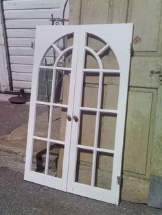 an old white double door on the side of a building